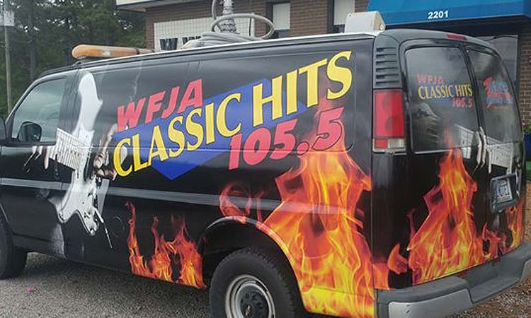 WFJA/WWGP Radio van. A black van featuring WFJA's logo, a guitar being strummed, and flames.