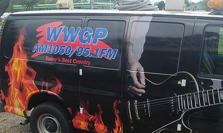 WFJA/WWGP Radio van. A black van featuring WWGP's logo, a guitar being strummed, and flames.