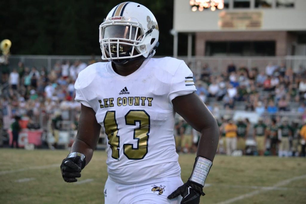 A football player from Lee Senior. His uniform is white with gold lettering and bares the number 43.