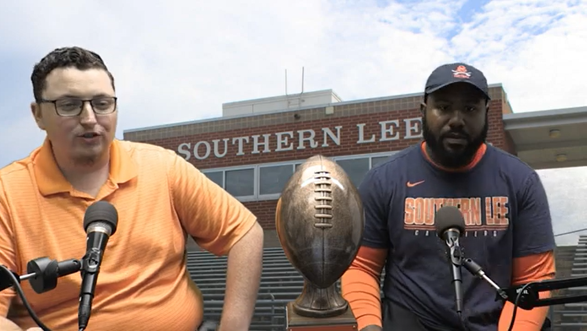 Sports host Austin Thomas sits with Coach McClure with the Southern Lee High School football field in the background