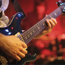 A guitarist strums an electric guitar